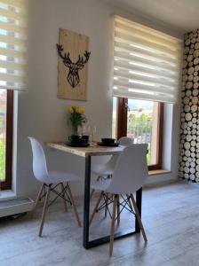 a dining room with a table and white chairs at Apartmán U Jelena, Čeladná in Čeladná +8 photos