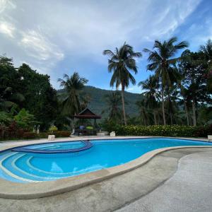 a swimming pool with palm trees and a gazebo at La Casa Bianca Samui in Amphoe Koksamui