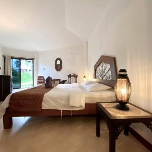 Un dormitorio con una cama grande y una mesa con una lámpara. en La Casa Bianca Samui, en Nathon Bay