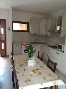 una cocina con una mesa con un jarrón de flores. en Experience comfort by the coast - Beahost Rentals, en Rosolina Mare