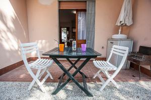una mesa con dos sillas y una mesa con bebidas. en Experience comfort by the coast - Beahost Rentals, en Rosolina Mare