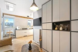 a kitchen and living room with white cabinets and a table at Modern Elegance in historical City Center in Trier
