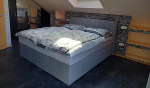 uma cama grande num quarto com uma parede de tijolos em Ferienwohnung Haus Peterstal em Trulben