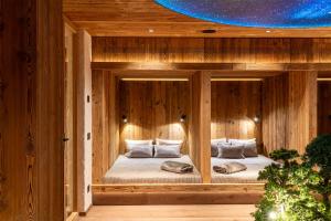 a bed in a wooden room with two pillows at Hotel Arkadia - "Adults Only" in Corvara in Badia