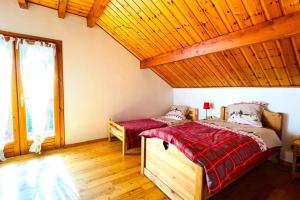 a bedroom with two beds and a wooden ceiling at CASA-Emmanuelle chalet Guillestre in Guillestre