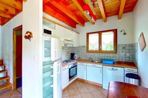 a kitchen with white appliances and a wooden ceiling at CASA-Emmanuelle chalet Guillestre in Guillestre