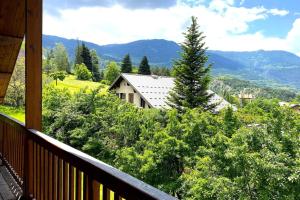 a balcony with a view of trees and a house at CASA-Emmanuelle chalet Guillestre in Guillestre