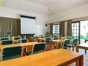 uma sala de aula com mesas e cadeiras de madeira e janelas em Park Gables Loftus em Pretoria