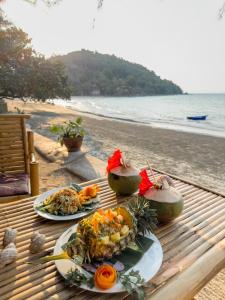 - deux assiettes de nourriture sur une table sur la plage dans l'établissement Full Moon Bungalow Resort Koh Chang Ranong, à Koh Chang Ranong