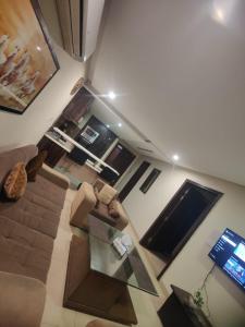 vistas panorámicas a una sala de estar con sofá y mesa en Urbanized Comfy Apartment en Rāwalpindi