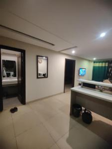 un salon avec une table et une télévision dans l'établissement Urbanized Comfy Apartment, à Rawalpindi