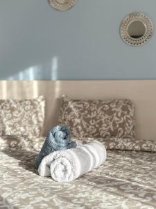 a stuffed animal laying on a bed with a towel at Bluesky Apartment AXD in Alexandroupoli