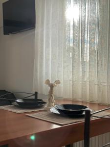 a wooden table with two plates and a bunny figurine on it at Bluesky Apartment AXD in Alexandroupoli +4 photos