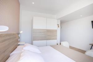 1 dormitorio con cama blanca y pared de cristal en Casa Senderos del Norte, en Sauzal