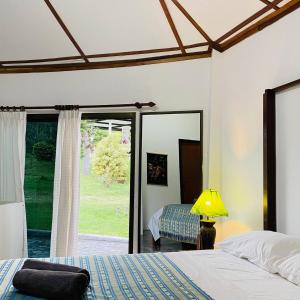 1 dormitorio con cama y espejo en La Casa Bianca Samui, en Nathon Bay