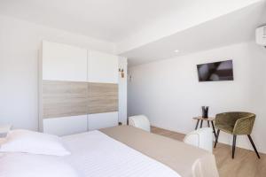 a white bedroom with a bed and a chair at Casa Senderos del Norte in Sauzal