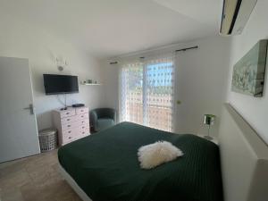 ein Schlafzimmer mit einem grünen Bett und einem weißen Kissen darauf in der Unterkunft Villa valle longa capicciola in Sainte-Lucie de Porto-Vecchio