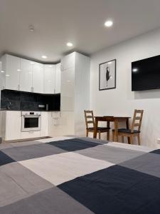 a kitchen with white cabinets and a table and chairs at OZO Life Apartment in Vilnius