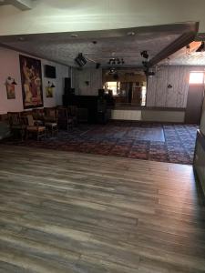 a large room with a wooden floor and a piano at Barley Mow Hotel in Pontefract