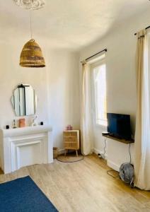 ein Wohnzimmer mit einem TV und einem Spiegel in der Unterkunft Minimalistic style of Baille by Weekome in Marseille