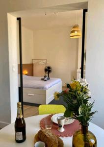 Zimmer mit einem Tisch mit einer Flasche Wein und einem Bett in der Unterkunft Minimalistic style of Baille by Weekome in Marseille