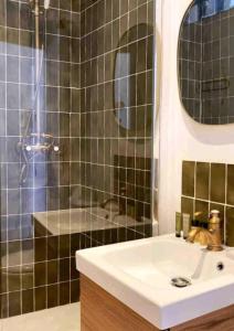 ein Bad mit einem Waschbecken und einer Dusche in der Unterkunft Minimalistic style of Baille by Weekome in Marseille