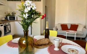 einen Tisch mit einer Flasche Wein und einer Vase Blumen in der Unterkunft Minimalistic style of Baille by Weekome in Marseille