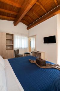 a bedroom with a blue bed with a tv on the wall at Gu Hotel in Guidonia