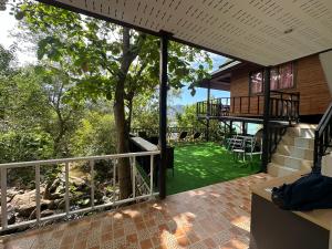 een uitzicht vanaf het terras van een huis met een boom bij Sweed Dee Seaview Hostel in Phi Phi Don