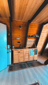 a kitchen with wooden cabinets and a wooden ceiling at Cottage Sataplia in Kutaisi