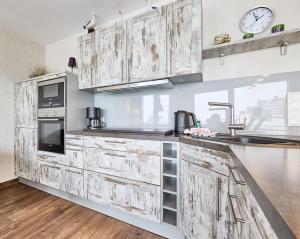 een keuken met houten kasten en een wastafel bij Nordico, FeWo 8 in Duhnen
