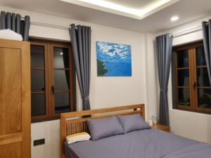ein Schlafzimmer mit einem Bett und einigen Fenstern in der Unterkunft Room in Apartment - Best Price Sun An Thoi Apartments for Long Stay in Phu Quoc