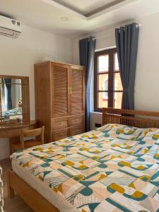 Schlafzimmer mit einem Bett, einem Schreibtisch und einem Fenster in der Unterkunft Room in Apartment - Best Price Sun An Thoi Apartments for Long Stay in Phu Quoc
