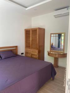 Schlafzimmer mit einem Bett, einer Kommode und einem Spiegel in der Unterkunft Room in Apartment - Best Price Sun An Thoi Apartments for Long Stay in Phu Quoc