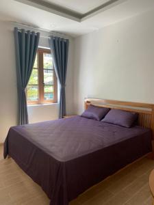 Schlafzimmer mit einem großen Bett und blauen Vorhängen in der Unterkunft Room in Apartment - Best Price Sun An Thoi Apartments for Long Stay in Phu Quoc