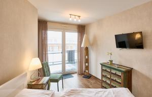een hotelkamer met een bed en een televisie bij Nordico, FeWo 8 in Duhnen