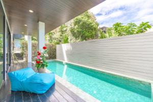 una piscina con un divano blu accanto a una casa di 3-Story Pool Villa Katazhang UTK B3 just 7 min walk to Kata Beach a Kata Beach