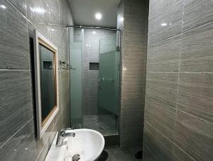 a bathroom with a sink and a glass shower at Ashers Villa in Abuja