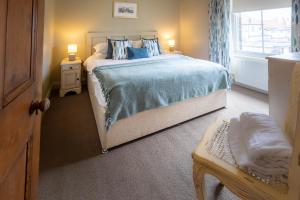 a bedroom with a large bed and a window at Pebble Cottage in Seahouses