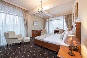 Habitación de hotel con cama y silla en Tbilisi Laerton Hotel, en Tiflis
