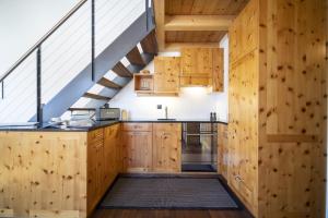 uma cozinha com armários de madeira e uma escada em Chasa Costa dad Archas Maisonette Wohnung em Scuol