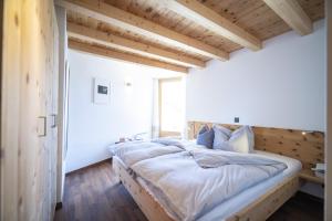 a bedroom with a large bed with a wooden headboard at Chasa Costa dad Archas Maisonette Wohnung in Scuol