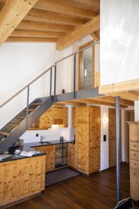 uma cozinha com armários de madeira e uma escada num loft em Chasa Costa dad Archas Maisonette Wohnung em Scuol
