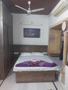 - une chambre avec un lit et un ventilateur de plafond dans l'établissement Stay With Us Home Stay, à Jaisalmer