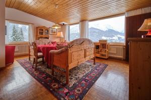 a dining room with a table and a large window at Chasa Panorama in Scuol