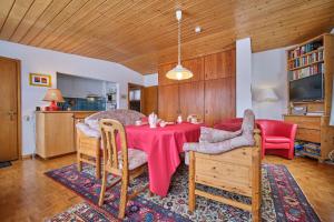 a dining room with a red table and chairs at Chasa Panorama in Scuol