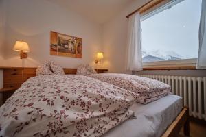 施庫爾的住宿－Chasa Panorama，一间卧室设有一张床和一个窗口