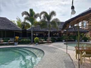 een resort met een zwembad en palmbomen bij Alunsina Hotel and Spa in Roxas City