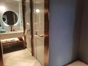 W łazience znajduje się prysznic i lustro. w obiekcie LanOu Hotel Huai'an Lianshui High-Speed Railway Station Yanhuang Avenue w mieście Lianshui