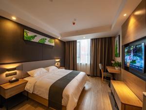 Habitación de hotel con cama y TV de pantalla plana. en Thank Inn Chain Yichang Sanxia Airport, en Yichang